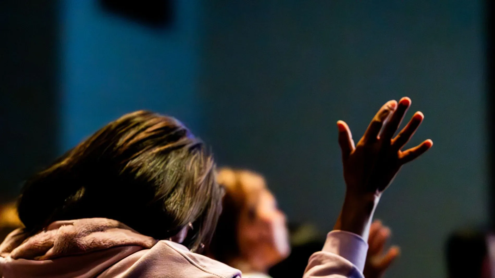Erhobene Hände im Gottesdienst, warmes Gegenlicht