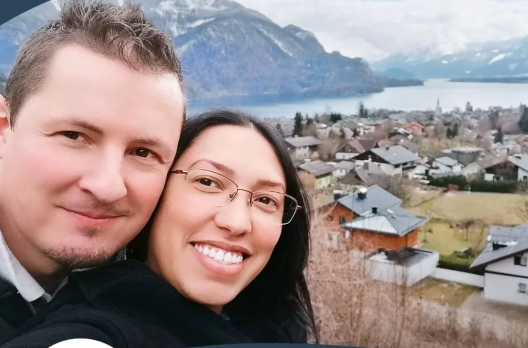 Pastor Stefan Wiesinger und Nohemy Wiesinger vor einer Berg- und Seelandschaft